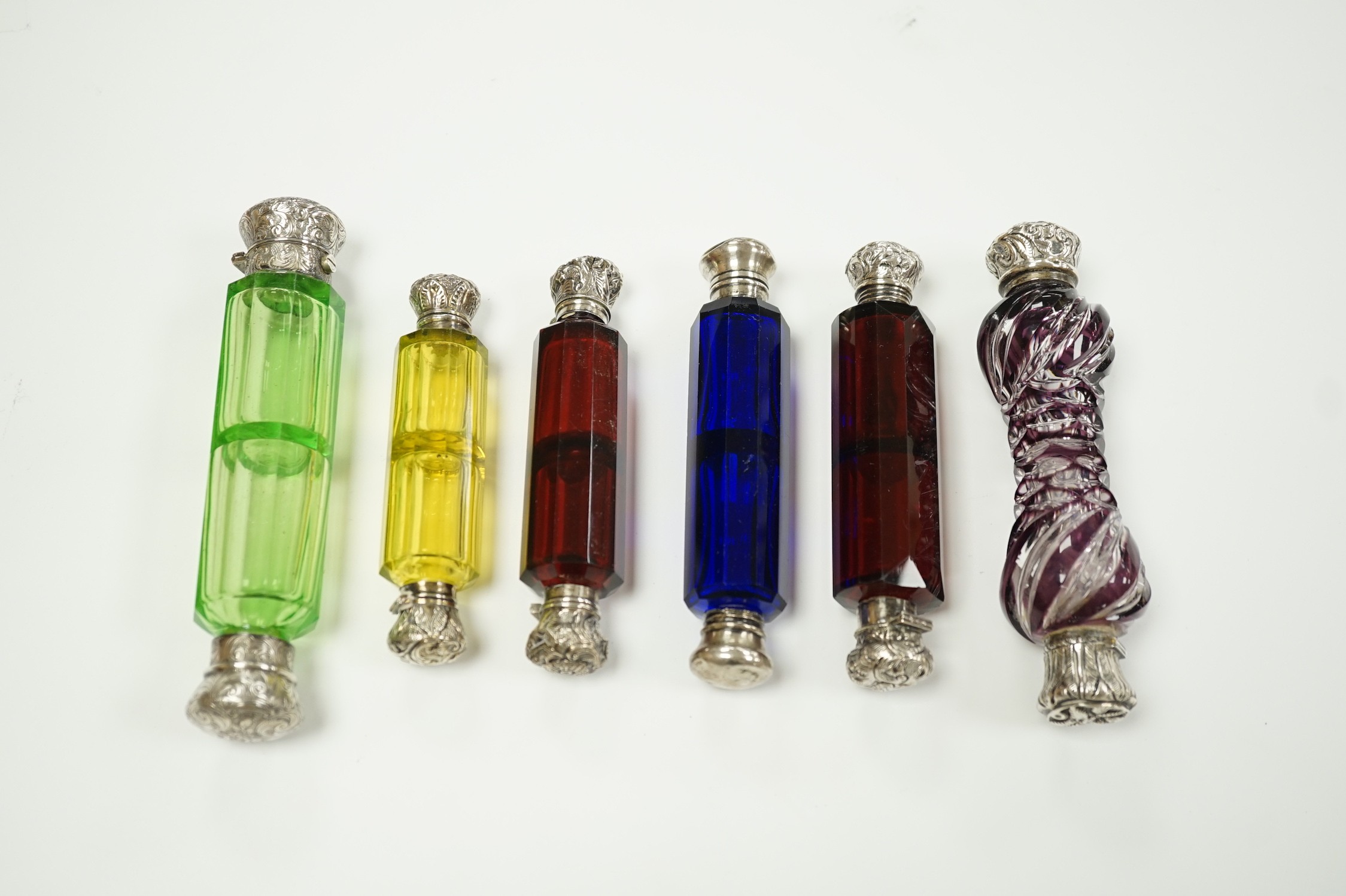 Six assorted late 19th/early 20th century white metal mounted coloured glass double ended scent bottles including pale green, 14.9cm and amethyst flash, 13.7cm (some a.f.)